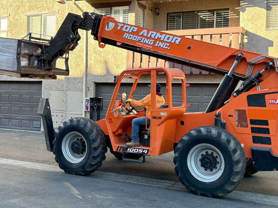 Branded telehandler placing materials at a community re-roof