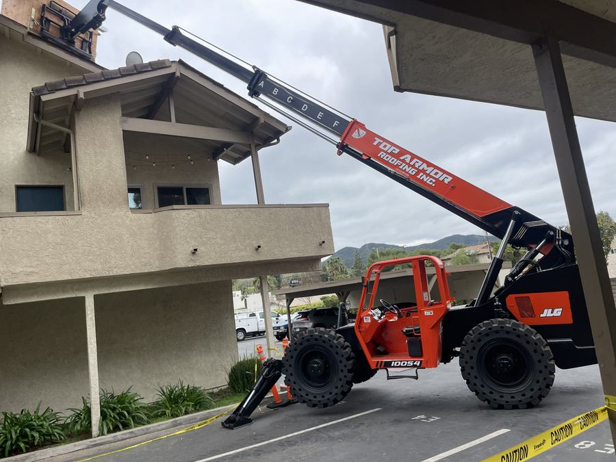 Telehandler boom over a two-story building